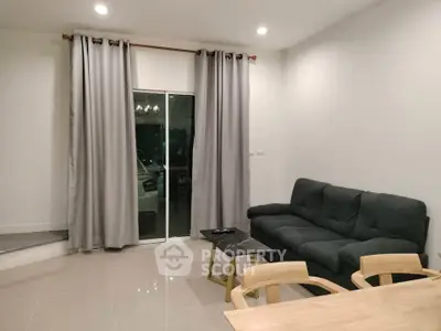Modern living room with sleek furniture and large window for natural light.