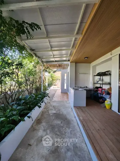 Charming outdoor kitchen area with lush greenery and covered walkway
