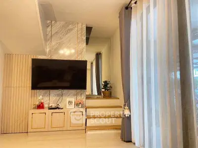 Modern living room with stylish decor and large TV on wall