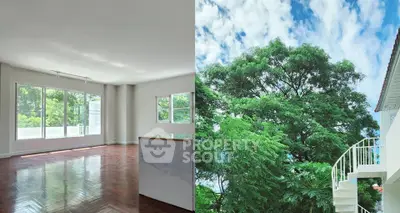 Spacious living room with large windows and lush green view