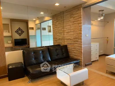 Modern living room with stylish stone accent wall and sleek black leather sofa