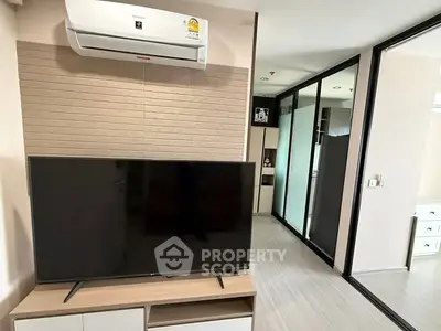 Modern living room with sleek TV setup and air conditioning in stylish apartment.