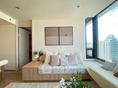 Modern living room with city view, cozy seating, and elegant decor in a high-rise apartment.