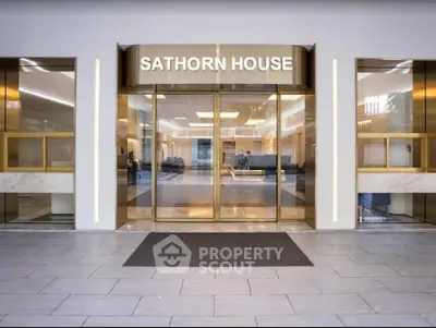 Elegant entrance of Sathorn House with modern glass doors and sleek design.