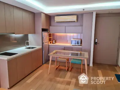 Modern kitchen with sleek wooden cabinetry and integrated appliances, complemented by a cozy dining area, perfect for urban living.