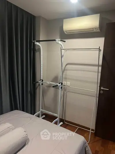 Cozy bedroom with air conditioning and exercise equipment, perfect for a healthy lifestyle.