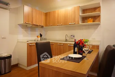 Modern kitchen with wooden cabinets and dining area in cozy apartment