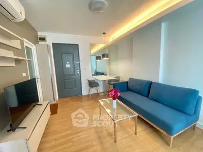 Modern living room with blue sofa, TV, and stylish decor