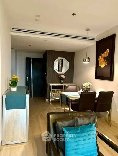 Modern living room with stylish decor and dining area, featuring elegant furniture and contemporary artwork.