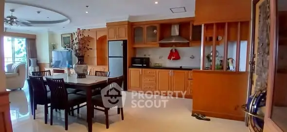 Spacious open-layout kitchen and dining area with modern appliances and elegant wooden cabinetry.