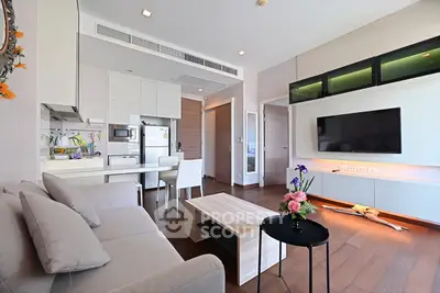 Modern living room with sleek furniture and open kitchen layout in a stylish apartment.
