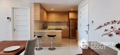 Modern kitchen with open layout, featuring sleek cabinetry and stainless steel appliances, seamlessly integrated into a cozy dining area.