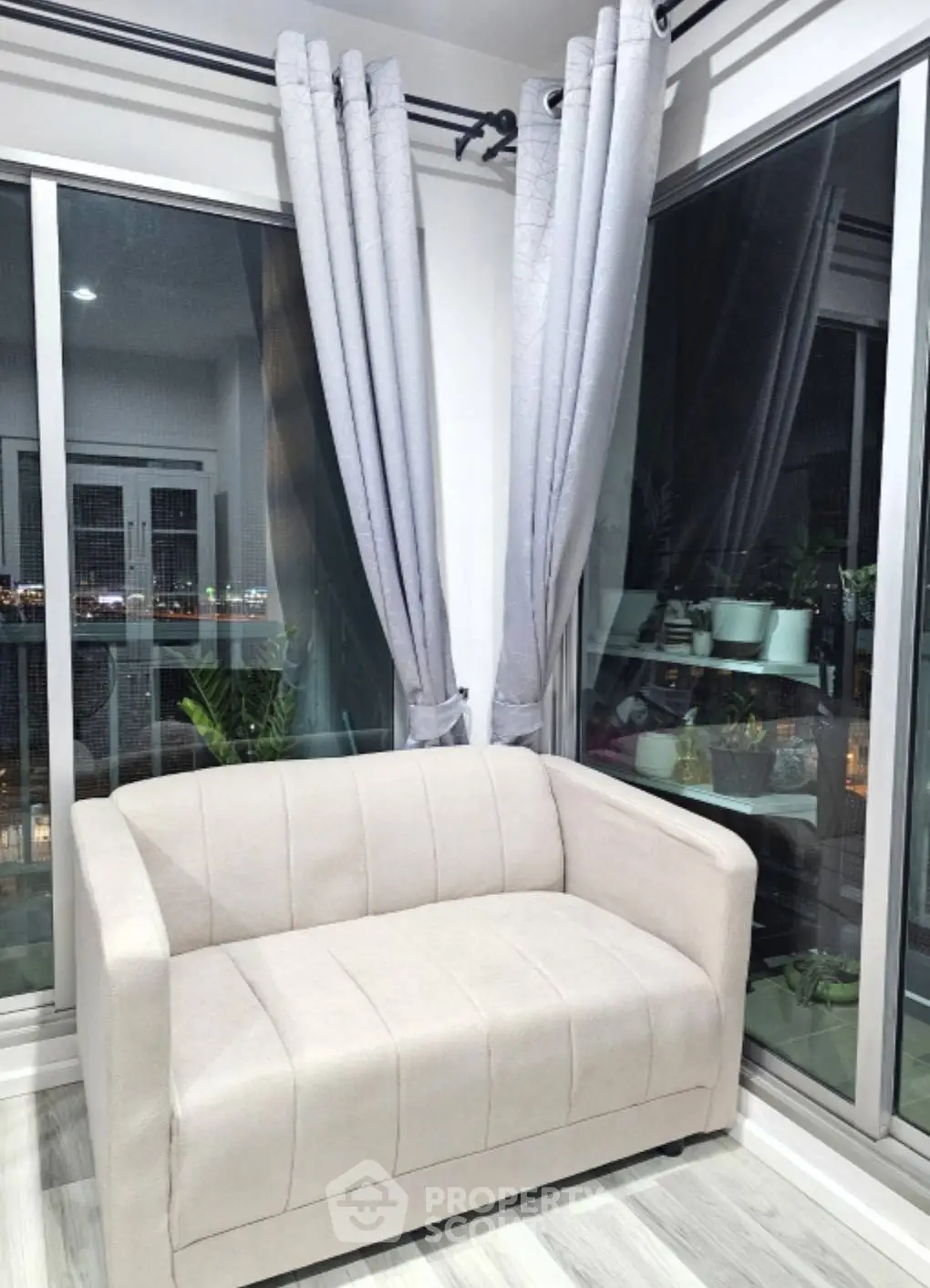 Modern living room with cozy beige sofa and large windows offering stunning city views.