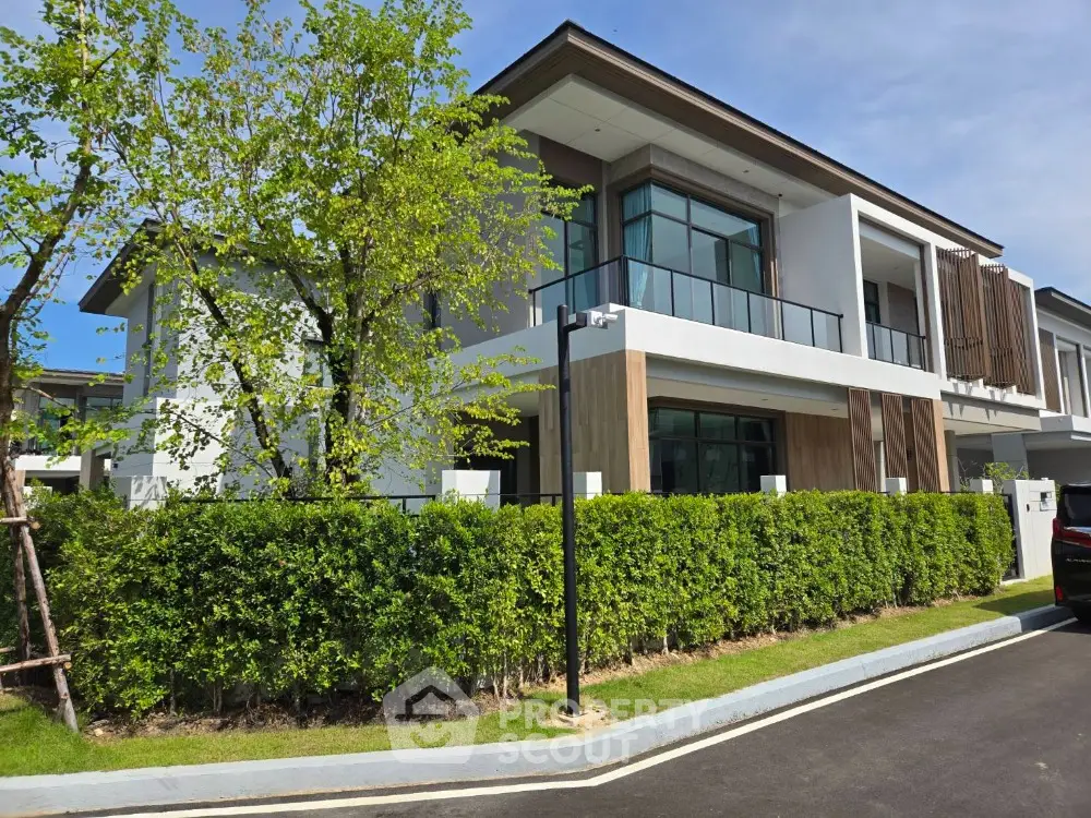 Modern two-story house with lush greenery and sleek architectural design