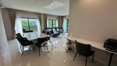 Spacious modern living room with dining area and large windows offering natural light.