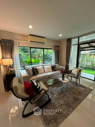 Elegant living room with garden view, modern furniture, and cozy ambiance.