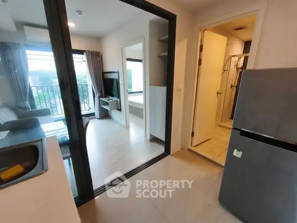 Modern apartment interior with open layout, featuring a cozy living room and sleek kitchen area.