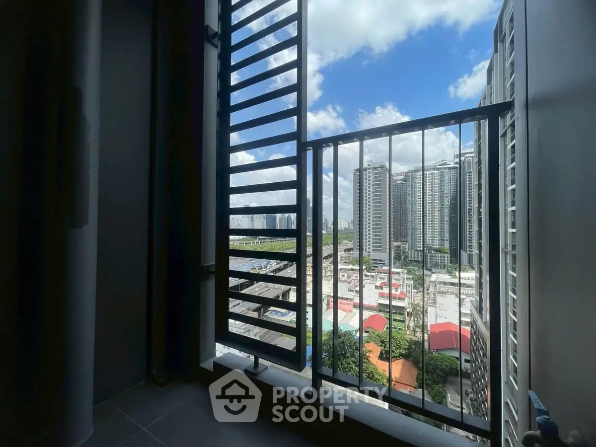 Stunning urban view from a high-rise balcony with city skyline and blue sky.