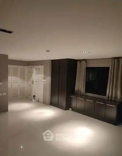 Spacious modern room with sleek storage and elegant lighting