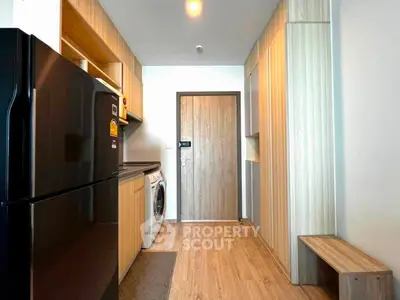 Modern kitchen with sleek appliances and wooden cabinetry in a stylish apartment.