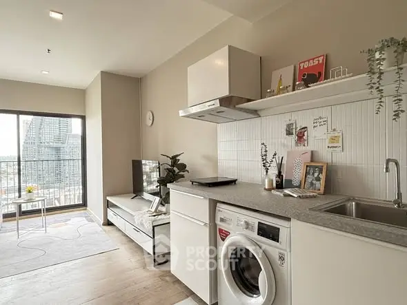 Modern open-plan living room and kitchen with city view, featuring stylish decor and built-in appliances.