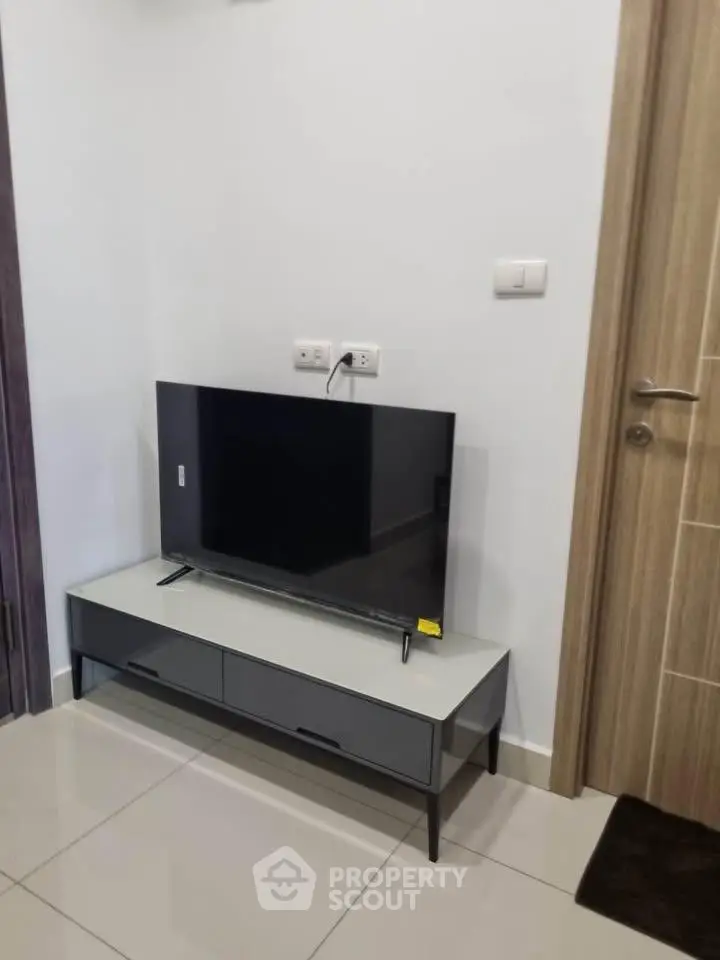 Modern living room corner with sleek TV stand and flat-screen TV, perfect for cozy entertainment.