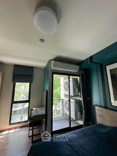 Modern bedroom with balcony and air conditioning, featuring stylish decor and natural light.