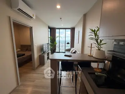 Modern open-layout apartment with kitchen and living room, featuring city view and stylish decor.