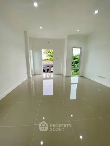 Spacious modern living room with glossy tiled floors and large windows for natural light.