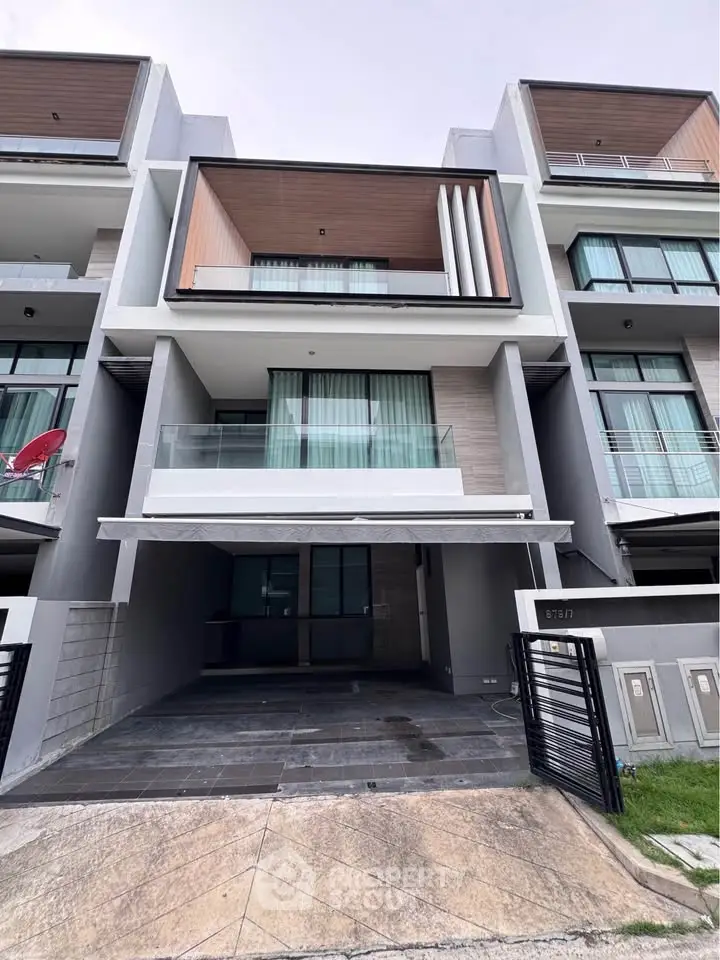 Modern multi-story townhouse with sleek design and spacious balcony in urban setting.