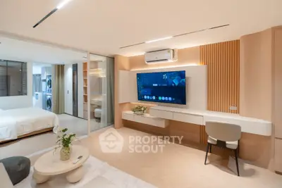 Modern living room with sleek design, large TV, and stylish furniture in a contemporary apartment.