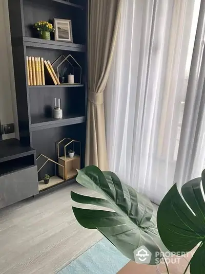 Elegantly designed living space with sophisticated gray shelving, chic decor, and flowing sheer curtains, creating a serene and stylish atmosphere.