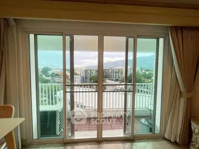 Spacious balcony with stunning city and mountain views from modern apartment.