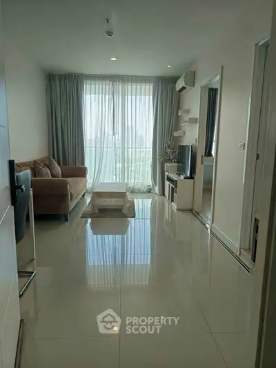 Spacious living room with modern decor and large window offering city views.