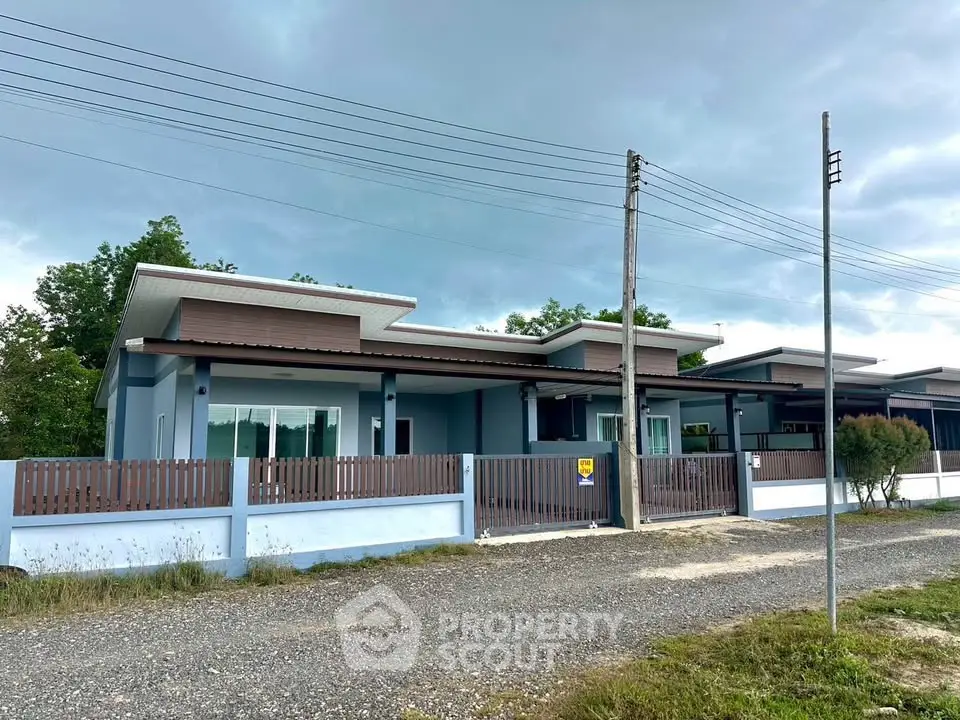 Modern single-story house with sleek design and spacious front yard in a serene neighborhood.