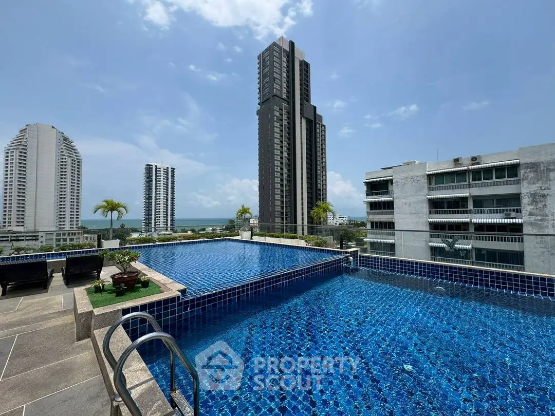 Luxurious rooftop pool with stunning cityscape and ocean views in modern high-rise building.