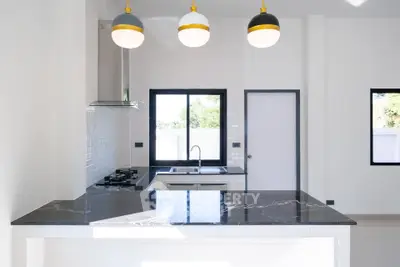 Modern kitchen with sleek black countertops and stylish pendant lighting