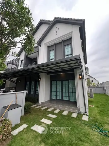 Modern two-story house with manicured lawn and stylish exterior design.