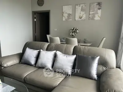 Elegant living room with plush leather sofa and chic dining area, perfect for modern urban living.