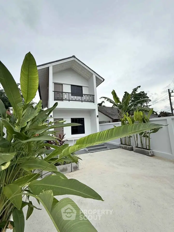 Modern two-story house with lush greenery and spacious driveway