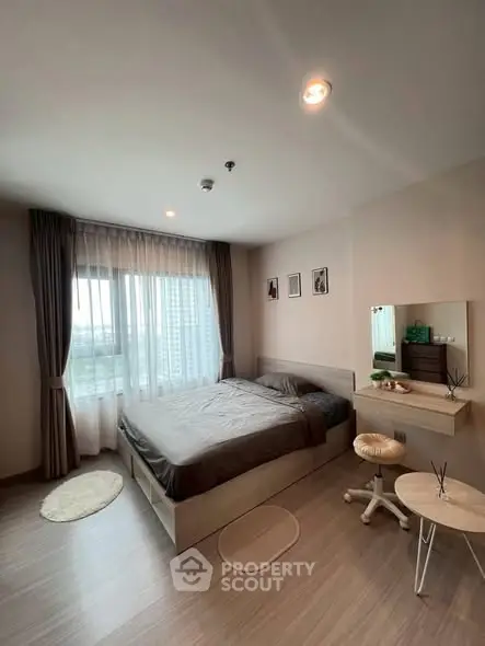 Modern bedroom with large window and stylish decor in a high-rise apartment.