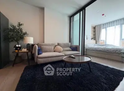 Modern living room with cozy sofa and stylish decor adjacent to a bedroom