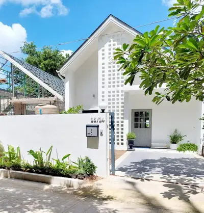 Charming modern white house with lush garden and sleek entrance