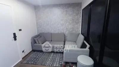 Modern living room with stylish gray sofa and patterned rug