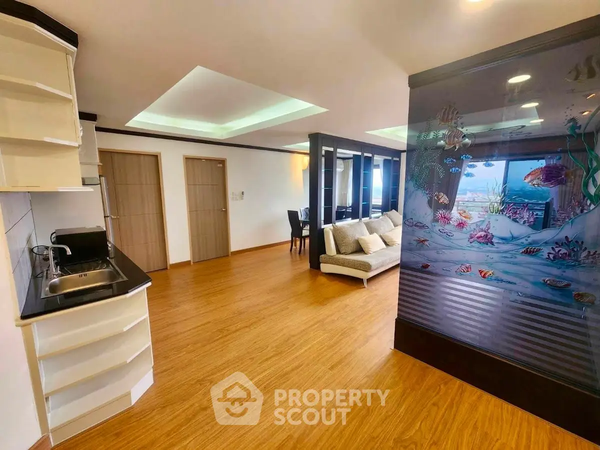 Spacious open-plan living room with unique aquarium feature and modern decor.