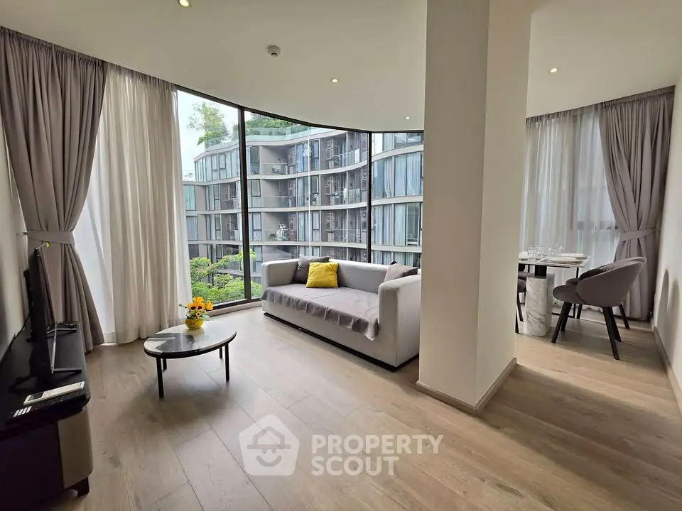 Spacious modern living room with large windows and elegant decor in a luxury apartment.