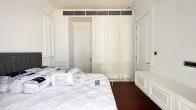 Luxurious bedroom with elegant white paneling and plush bedding in a modern apartment.