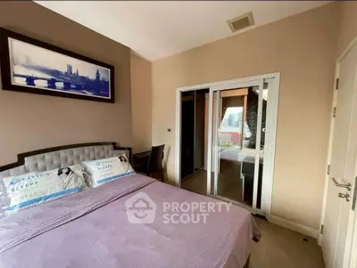 Cozy bedroom with modern decor and sliding glass doors leading to a balcony.