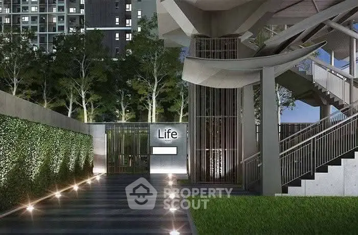 Modern building entrance with sleek design and lush greenery