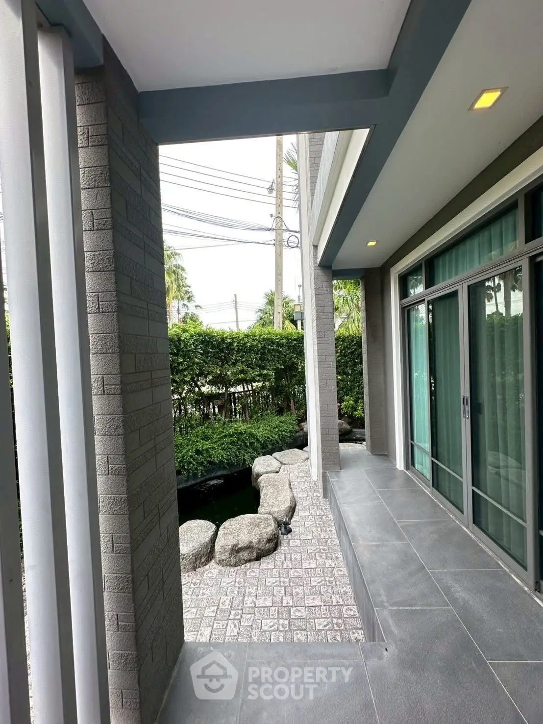 Modern home exterior with sleek patio and lush garden view